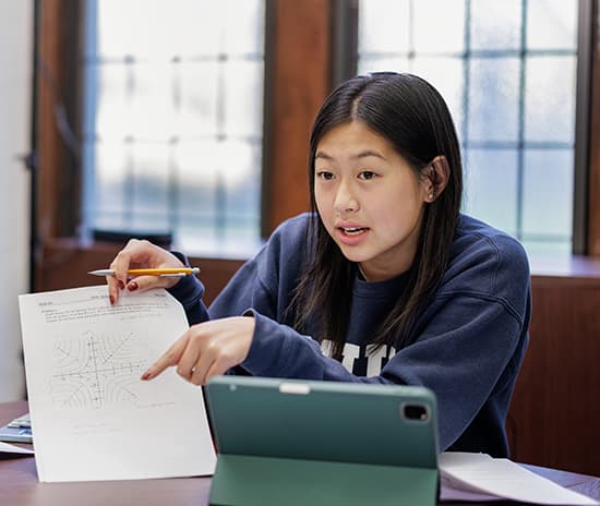 International student in class explaining coursework